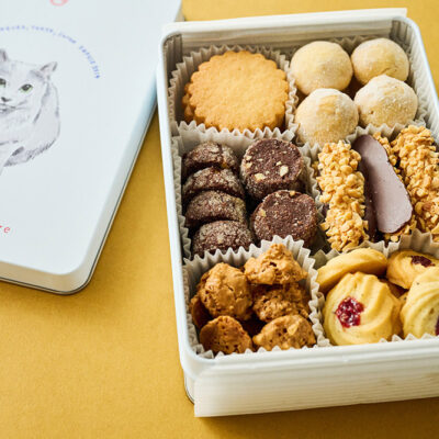 猫のイラスト入りの缶と多彩な焼き菓子が詰まったアディクト オ シュクルのクッキー缶