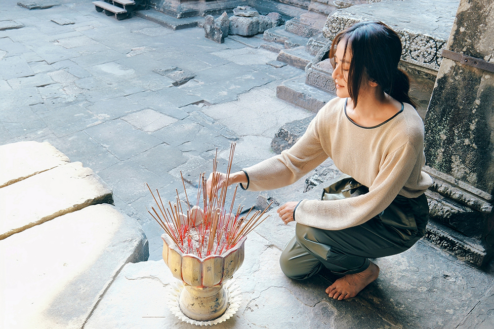 旅先にて、静かに線香を供えるクリス-ウェブ佳子さん