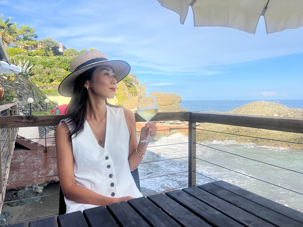 海辺のレストランで白ワインを楽しむマリーニあゆみさん