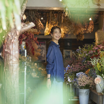 学芸大学のフラワーショップ「THE DAFFODILS」で季節の花々に囲まれて微笑む ファッションコーディネーター・佐藤匠さん