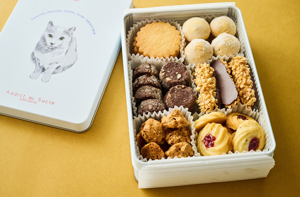 猫のイラスト入りの缶と多彩な焼き菓子が詰まったアディクト オ シュクルのクッキー缶
