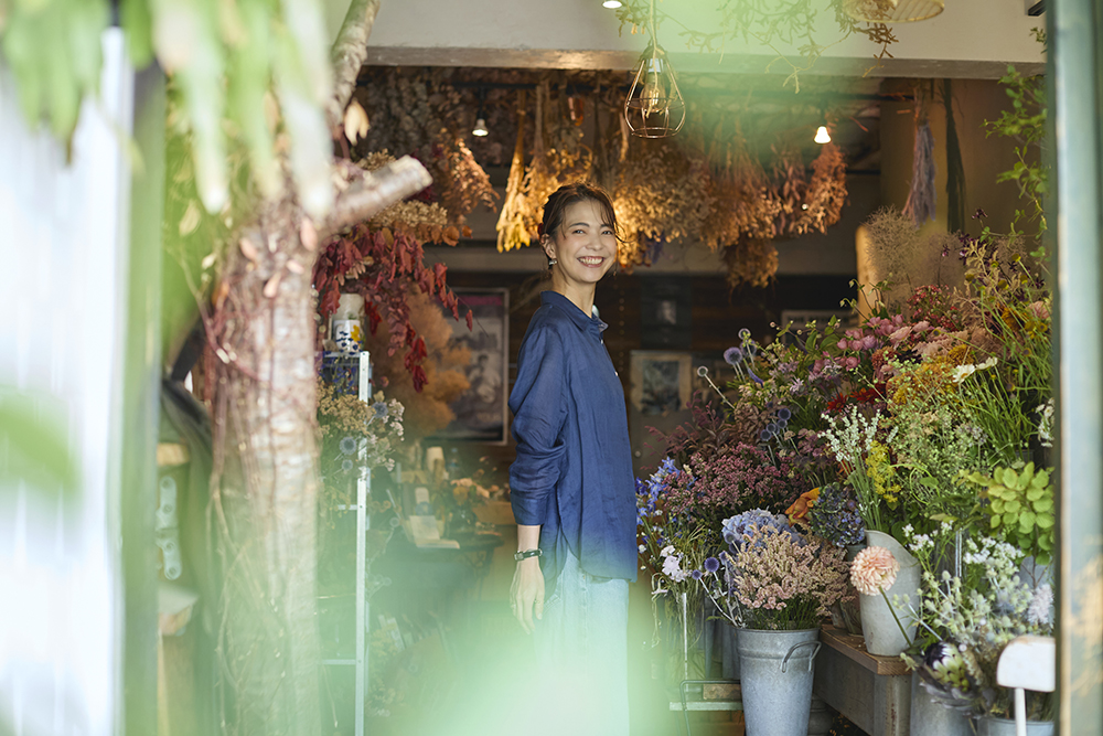 学芸大学のフラワーショップ「THE DAFFODILS」で季節の花々に囲まれて微笑む ファッションコーディネーター・佐藤匠さん