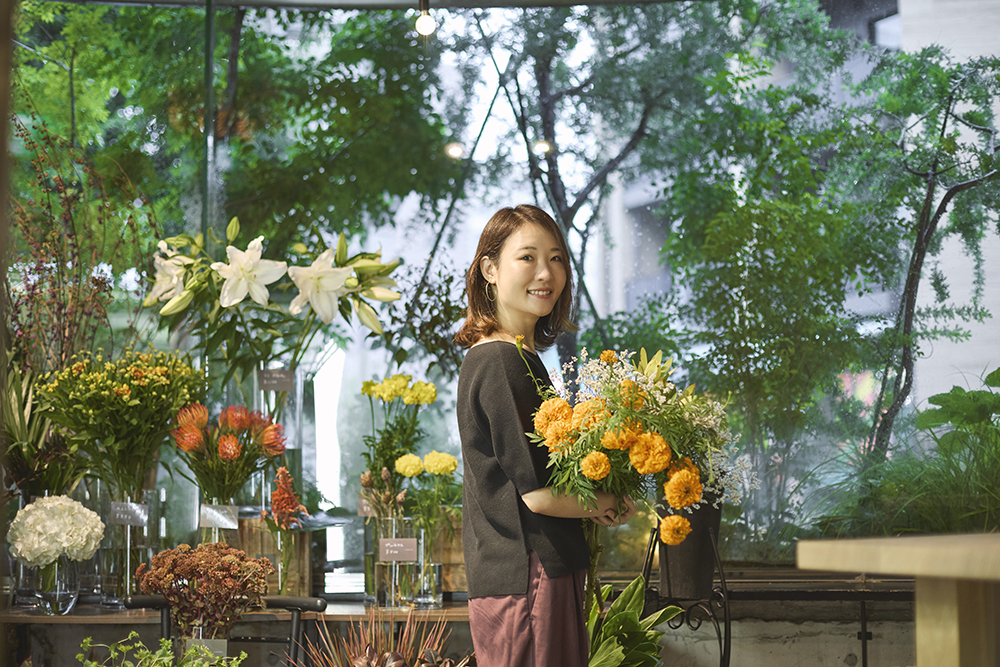 色鮮やかな花に囲まれる福寿満希さん
