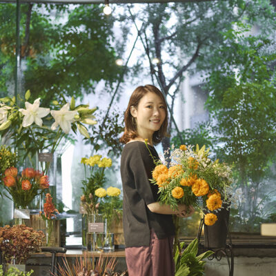 色鮮やかな花に囲まれる福寿満希さん