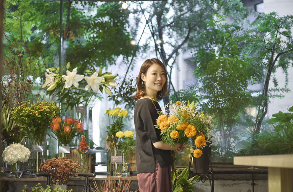 色鮮やかな花に囲まれる福寿満希さん